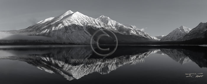 Mountains reflect in Lake McDonald on a cool spring morning, Glacier National Park, Montana, U.S.