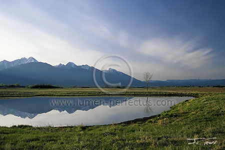 The Mission Range reflects in a kettle pond in Ninepipe NWR, Montana, U.S.