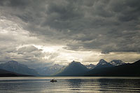 Kayaker under stormy sky on Lake McDonald, Glacier National Park, Montana, U.S.